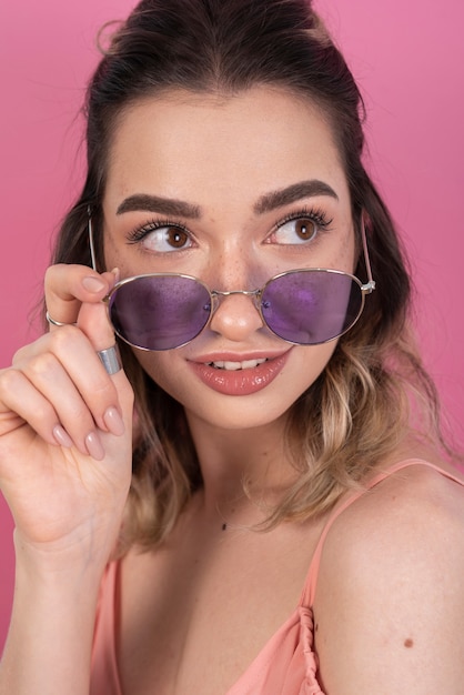 Бесплатное фото Женщина позирует с фиолетовыми очками