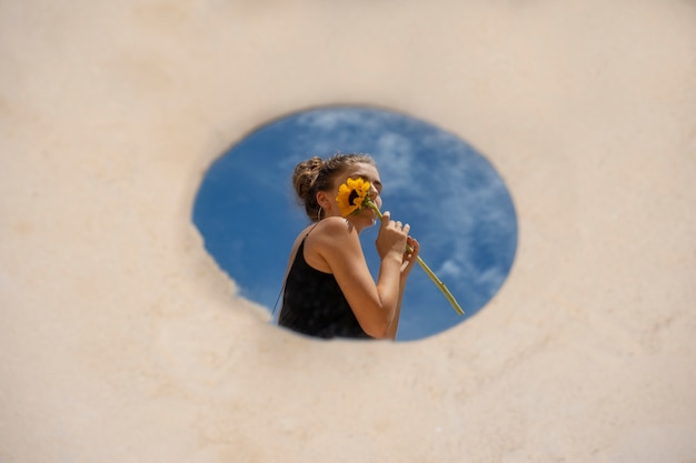 Woman posing with round mirror and flower