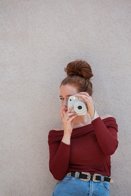 Foto gratuita donna che posa con una macchina fotografica d'annata