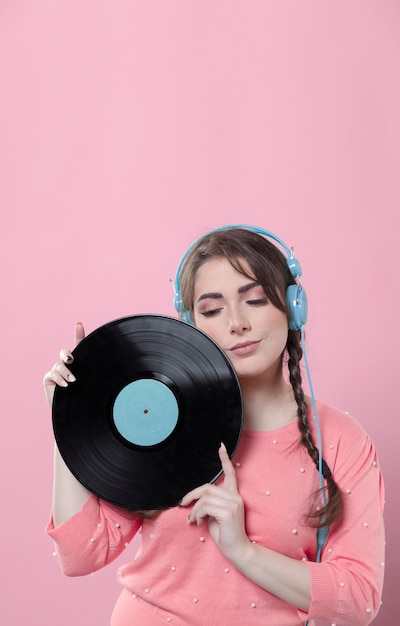 woman posing with vinyl record and headphones