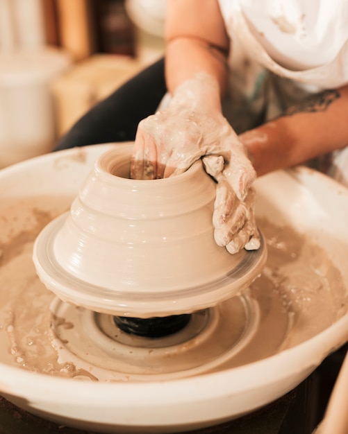 女性陶芸家の手は陶器のホイールになります