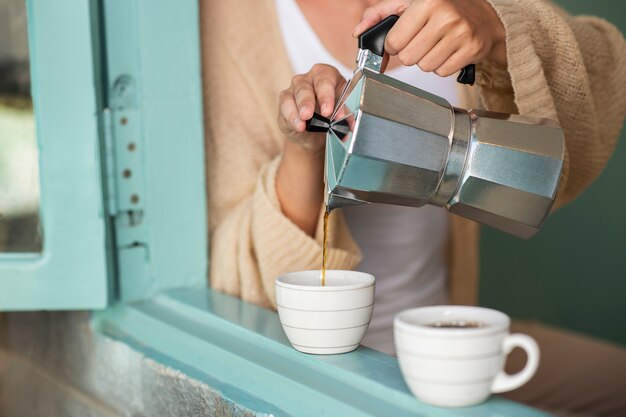 彼女と彼女のボーイフレンドのためにコーヒーを注ぐ女性