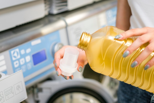 Free photo woman pouring detergent in cap