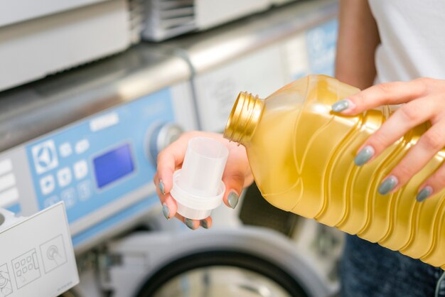 Woman pouring detergent in cap