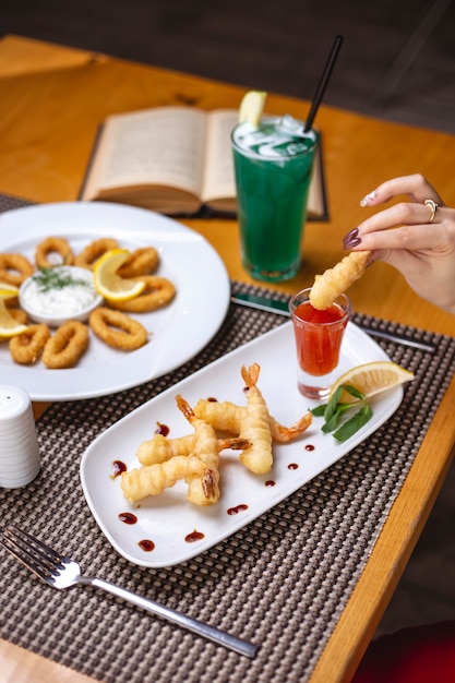 Free photo woman pouring fried prawn in sweet chili sauce lemon mint side view