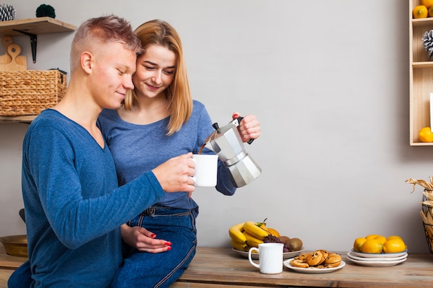 Free photo woman pouring her boyfriend some coffee with copy space