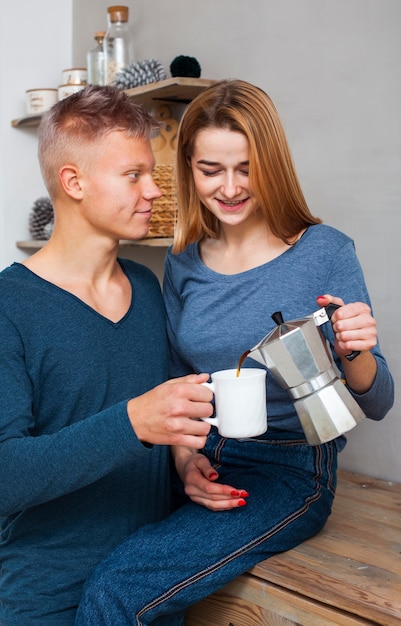 Foto gratuita donna che versa al suo ragazzo del caffè