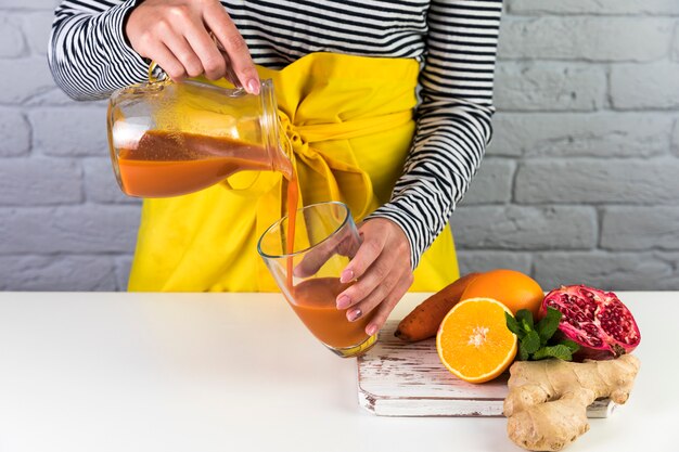 Woman pouring homemade smoothie in a glass