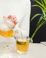 Free photo woman pouring tea from crystal teapot