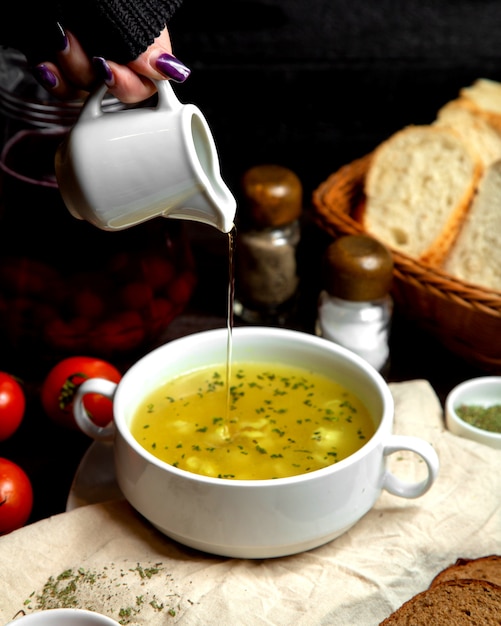 Foto gratuita donna che versa aceto nella zuppa di gnocchi di dushbara