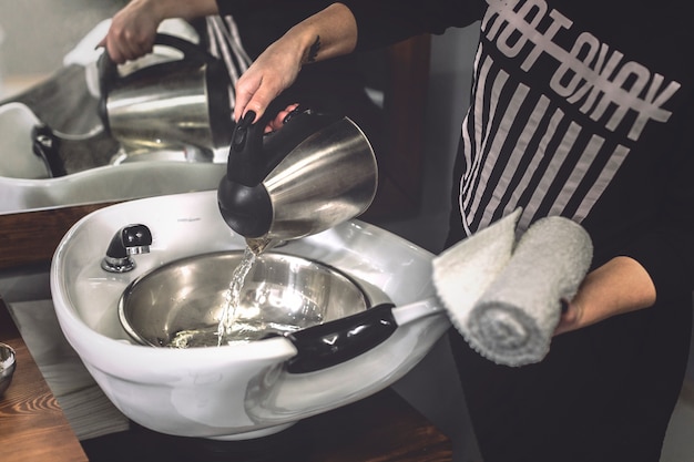 Free photo woman pouring water in barbershop