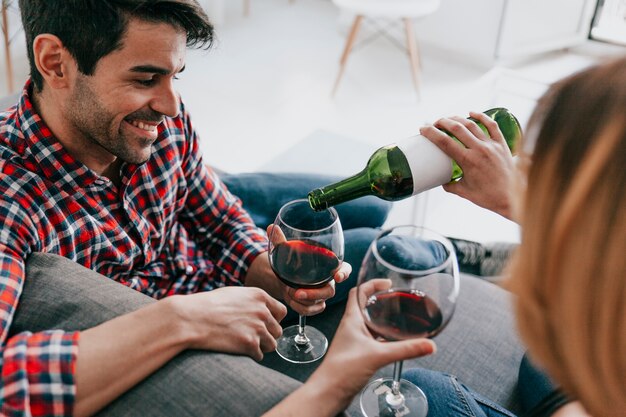 Woman pouring wine to man