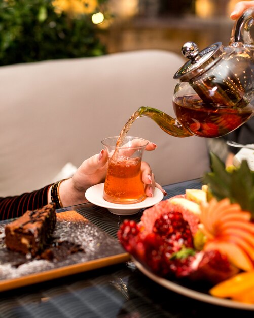 Woman pours tea into the armudu glass