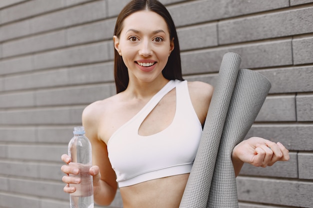 Foto gratuita donna che pratica yoga avanzato contro un muro urbano scuro