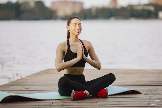 Donna che pratica yoga avanzato dall'acqua