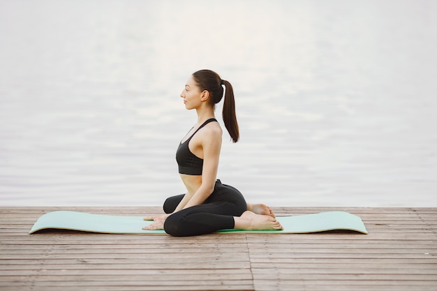 Donna che pratica yoga avanzato dall'acqua