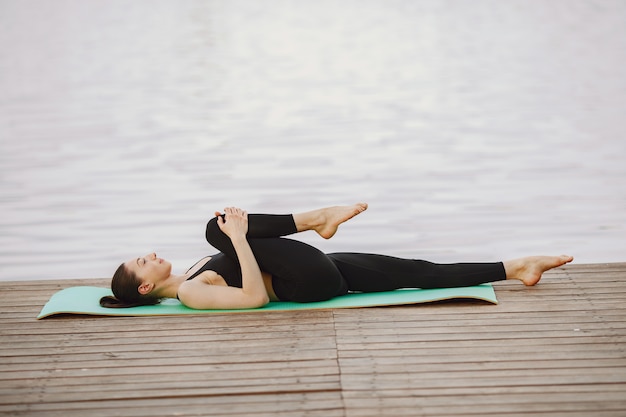 Foto gratuita donna che pratica yoga avanzato dall'acqua