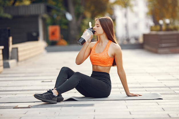 Woman practicing advanced yoga in a summer city