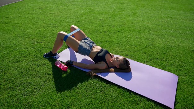 Woman practicing bridge butt raise using resistance band