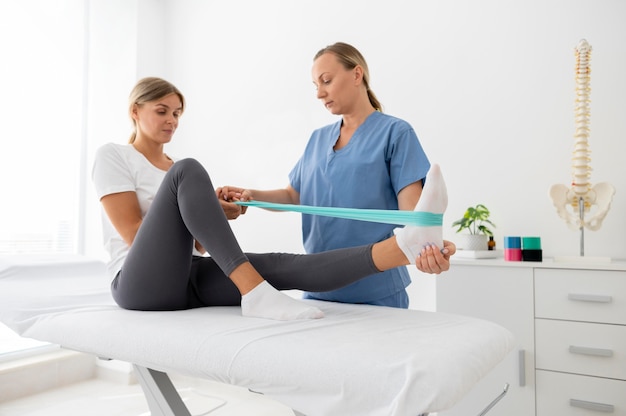 Женщина делает упражнения на сеансе физиотерапии
