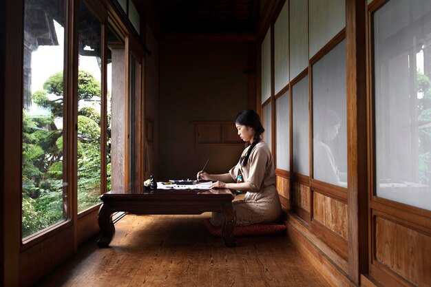 Woman practicing japanese handwriting at home