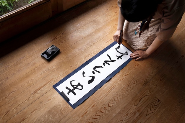 Woman practicing japanese handwriting at home