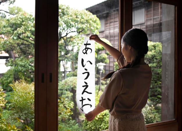 Woman practicing japanese handwriting at home