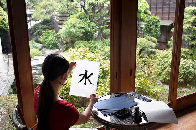 Woman practicing japanese handwriting indoors