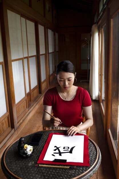 Woman practicing japanese handwriting indoors