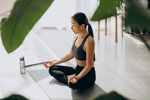 Donna che pratica yoga sul tappetino a casa