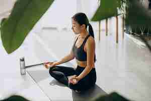 Free photo woman practicing yoga on mat at home