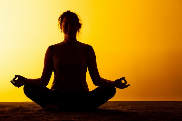 Woman practicing yoga in the sunset light