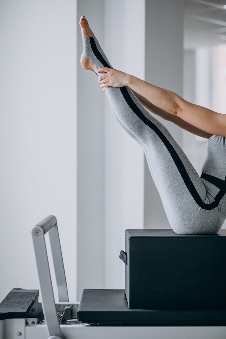 Free Photo woman practising pilates in a pilates reformer legs close up