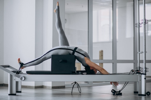 Free photo woman practising pilates in a pilates reformer