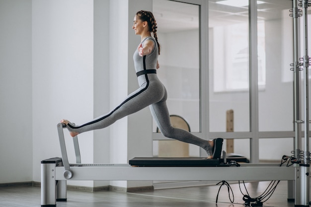 Free photo woman practising pilates in a pilates reformer