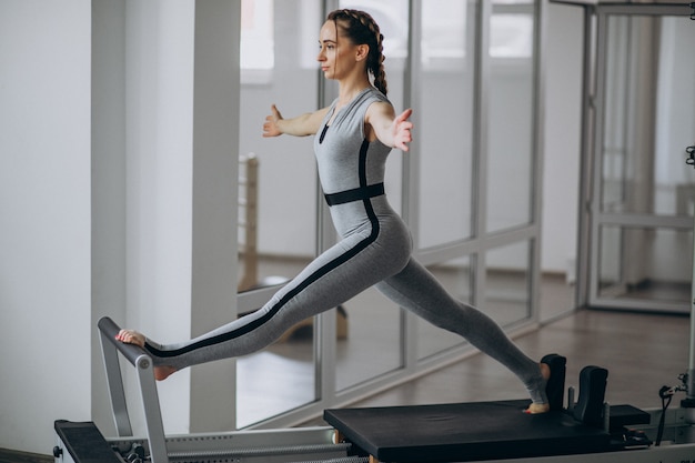 Free photo woman practising pilates in a pilates reformer