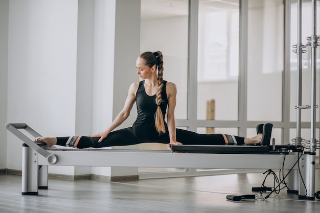 Free photo woman practising pilates in a pilates reformer