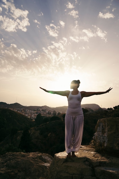 Donna che pratica yoga in campagna