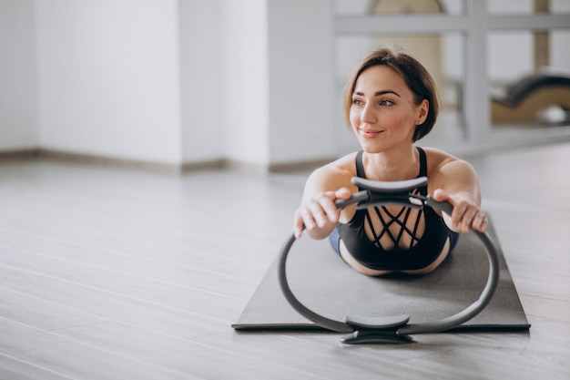 Donna che pratica yoga in palestra su una stuoia