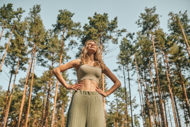 A woman practising yoga in the park and looking involved