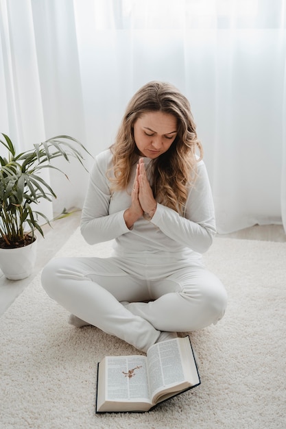 床で家で祈る女性