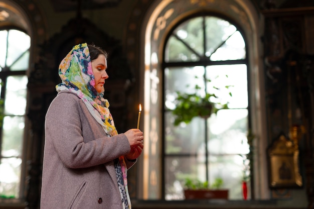 宗教的な巡礼のために教会で祈る女性