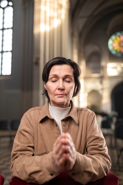 Foto gratuita donna che prega in chiesa