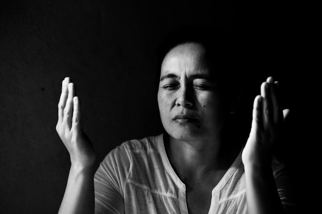 woman praying with her eyes closed