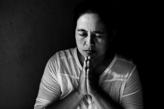 woman praying with her eyes closed