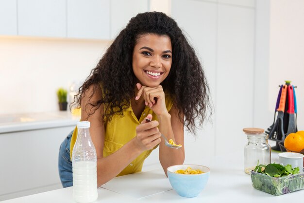 Woman preparing a bowl of cereals with milk