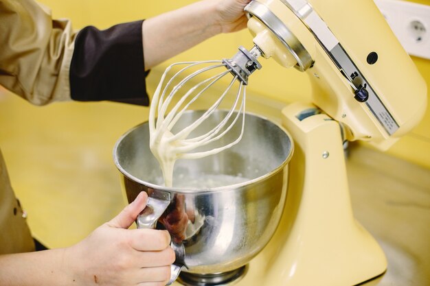 Woman preparing pastries. Confectioner in a coat.