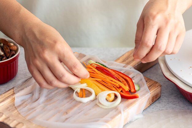 Foto gratuita donna che prepara gli involtini primavera in carta di riso sul tavolo della cucina