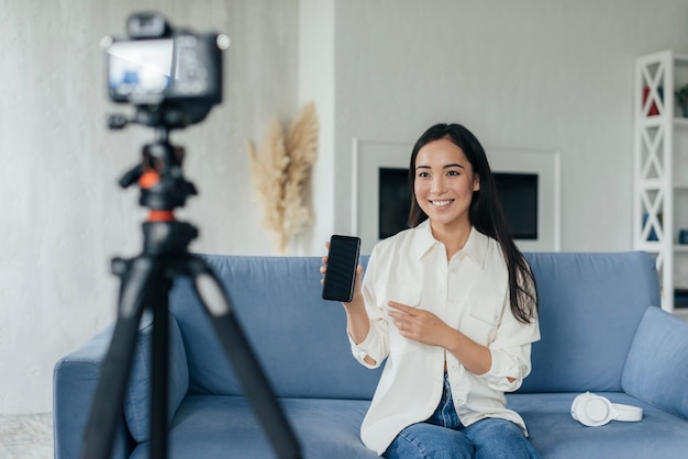 Free photo woman presenting her phone in a live stream