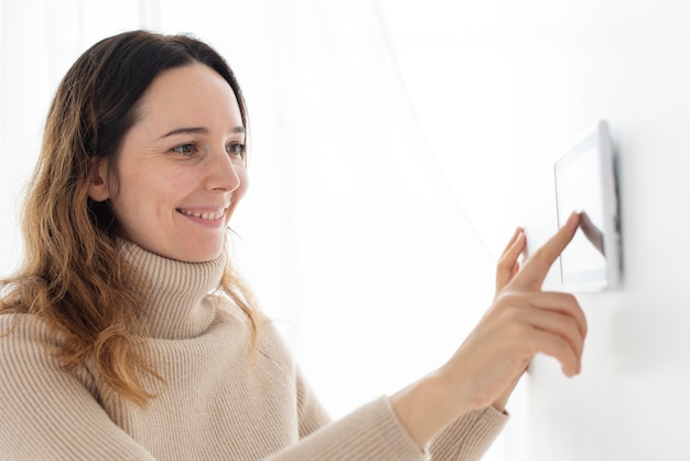 Foto gratuita donna che preme sul monitor del pannello domotico intelligente